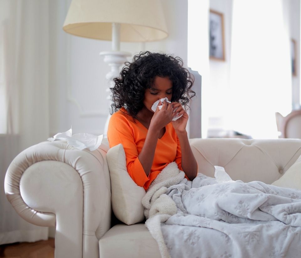 Ethical cold and flu remedies, a lady lies on the sofa, sneezing