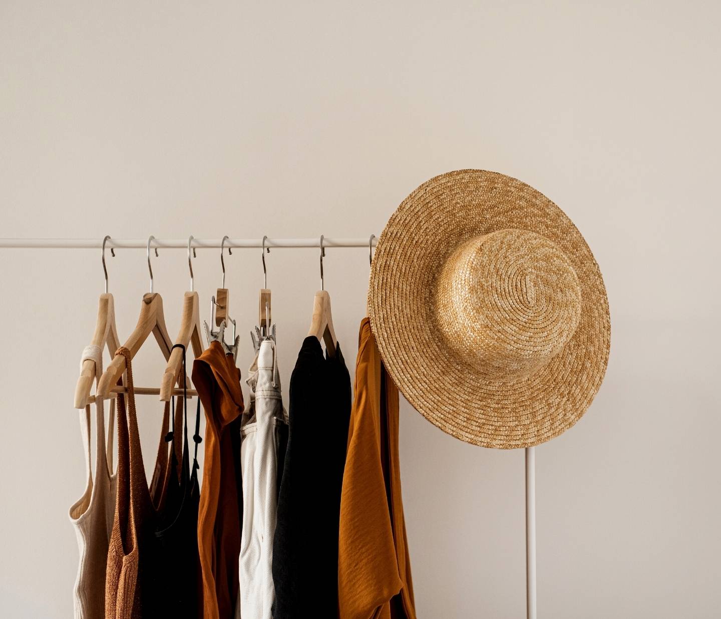 Ethical clothing on a clothes rail, with a straw hat